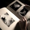 Black and white image of hands holding a book with three pictures - a pregnant mother, an ultrasound, and babu feet.