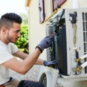 Man repairing an exterior home  air conditioning unit