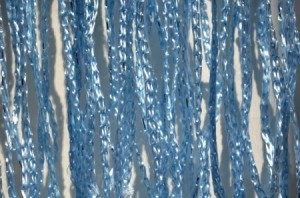 Close-up image of blue metallic strands of yarn against of white background