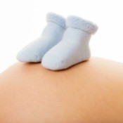 Blue booties on a pregnant belly.