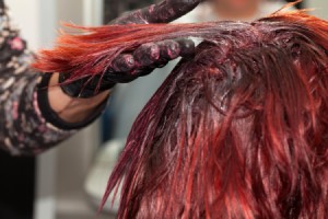 Hair being dyed red at the roots.