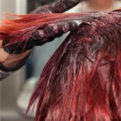 Hair being dyed red at the roots.