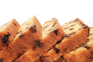 Loaf of date bread cut into slices against a white background