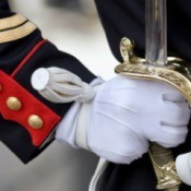 Close up of soldier in dress uniforms gloved hand holding sheathed sword