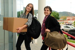 Two college students moving into their dorm.