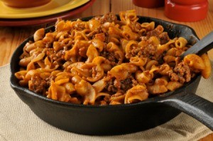 Hamburger, noodle and red sauce casserole in a cast iron skillet