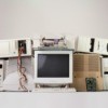 Several old tube style computer monitors and 1990s era CPUs stacked against a white background