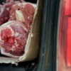 Raw beef on a piece of cardboard in the back of an SUV style car (lift gate is open)