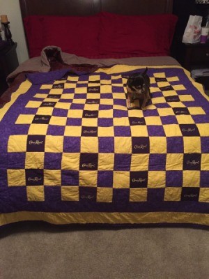 Crown Royal quilt on bed with puppy