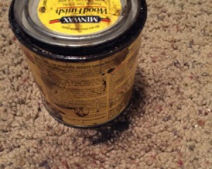 Wood Stain can  with ring of varnish stain marking the carpet around the can