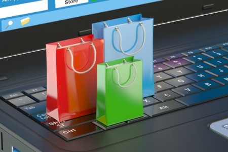 Three tiny gift bags standing on a laptop keyboard