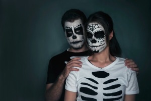 Couple in t-shirts ripped to look like a skeleton and sugar skull facepaint
