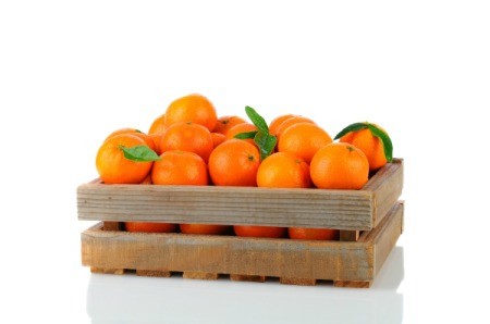 Clementines in wooden box against white background