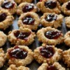 Thumbprint cookies with jam filling on a cookie sheet