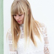 Woman in white lace shirt gazing down