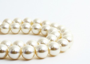 Strands of pearl necklace against a white background