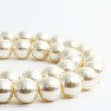 Strands of pearl necklace against a white background