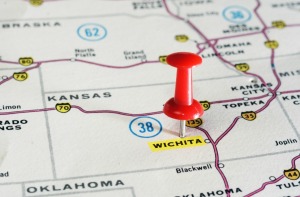 Close out of map with red push pin on Wichita, Kansas.  The word Wichita is highlighted.