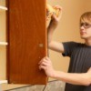 Man sanding kitchen cabinet door