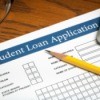 Close up image of student loan application with pencil and calculator