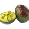 A whole avocado, half avocado, and some diced avocado against a white background