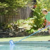 A man cleaning his backyard pool.