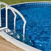 Above ground pool off of a deck with sparkling clean water