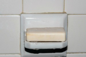 Wet, sudsy bar of soap on a shower soap shelf