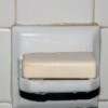 Wet, sudsy bar of soap on a shower soap shelf