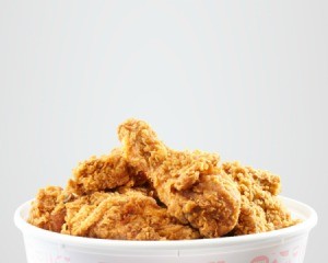 Fried chicken in paper bucket against a white background