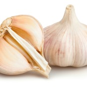 One full and one half bulb of garlic against a white background