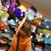 Woman checking prices on rolls of plush and fleece fabrics