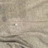 Close up of a small hole in a grey t-shirt