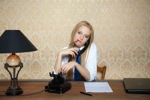 Woman talking on phone will smoking a cigarette in front of vinyl wallpaper