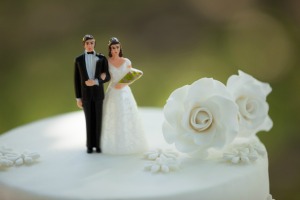 Bride and Groom figurines on the top of a wedding cake with a flower