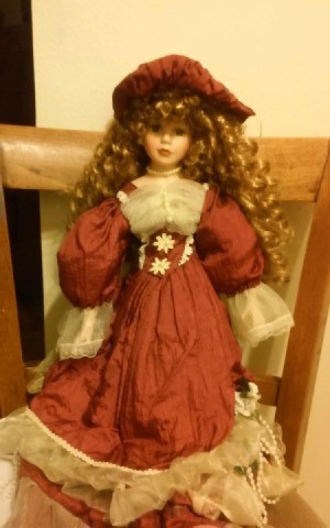 doll with red hair wearing a fancy rust colored dress with ecru lace