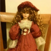 doll with red hair wearing a fancy rust colored dress with ecru lace
