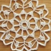 Starched white doily against a wooden background