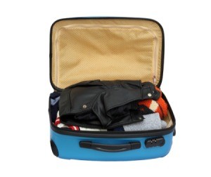 Small packed suitcase open against a white background