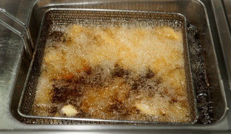 Close up of food being fried in a deep fat fryer