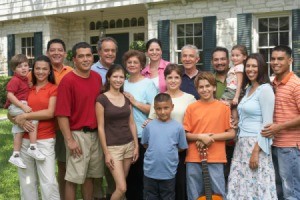 Several generations of a large family posed for a photo in front of home.