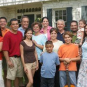 Several generations of a large family posed for a photo in front of home.