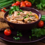 bowl of paprika chicken with bread and veggies
