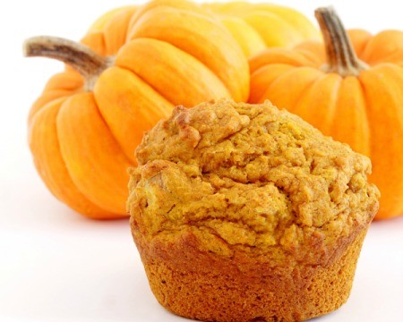 Pumpkin Spice Cupcake  in front of several small pumpkins