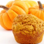 Pumpkin Spice Cupcake  in front of several small pumpkins