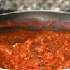 Close up image of red pasta sauce cooking in pan