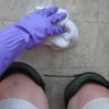 person wearing knee pads scrubbing the floor