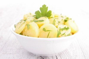 Potato salad that does not have mayo in a white bowl