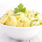 Potato salad that does not have mayo in a white bowl
