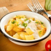 Bowl of potato salad using yellow potatoes and a dressing over the top